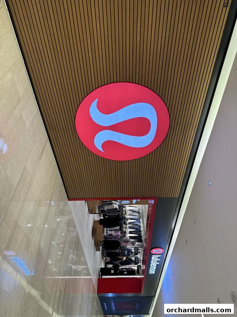 Lululemon store entrance with its iconic logo and display of athletic apparel.