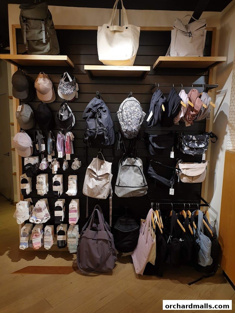 A display of lululemon bags, hats, and socks on shelves and racks.