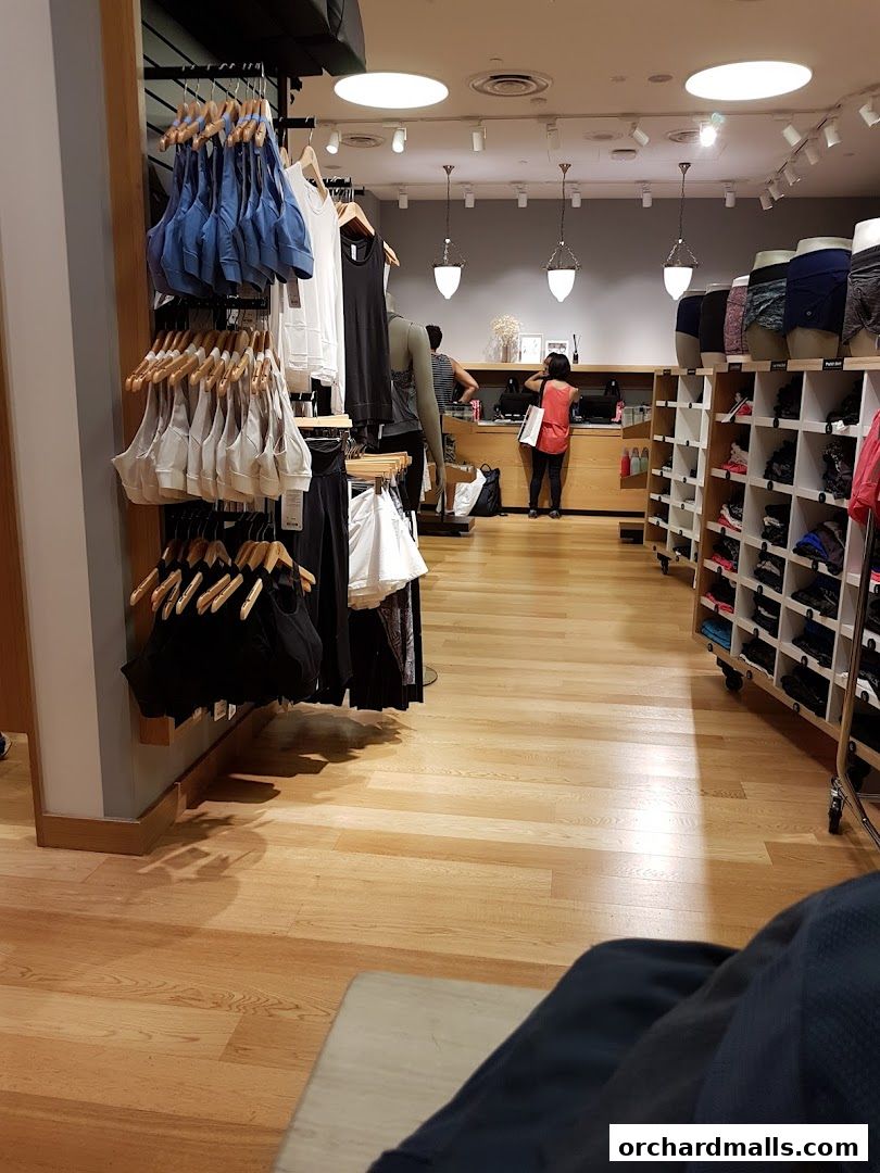 Interior view of a Lululemon store with activewear displayed on racks and shelves.