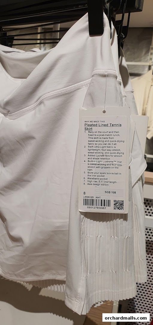 A white pleated tennis skirt from Lululemon with a product tag detailing its features and price.