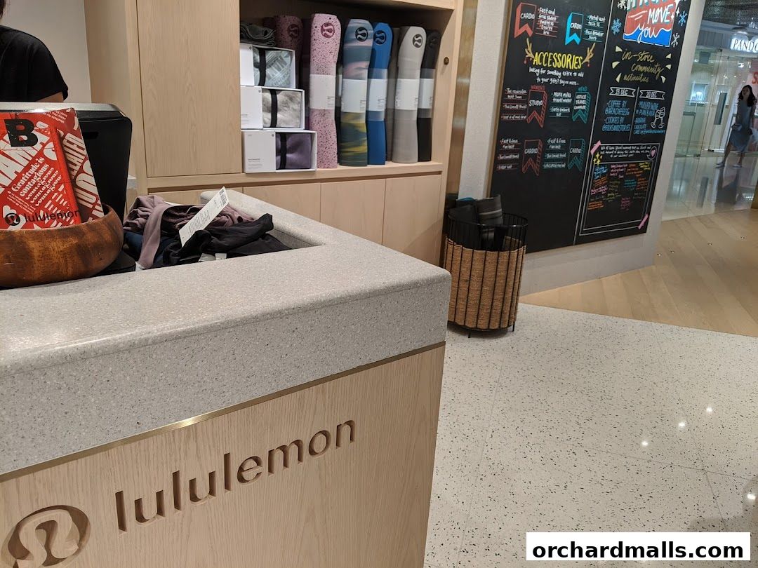 Lululemon store interior with yoga mats, apparel, and a promotional board.