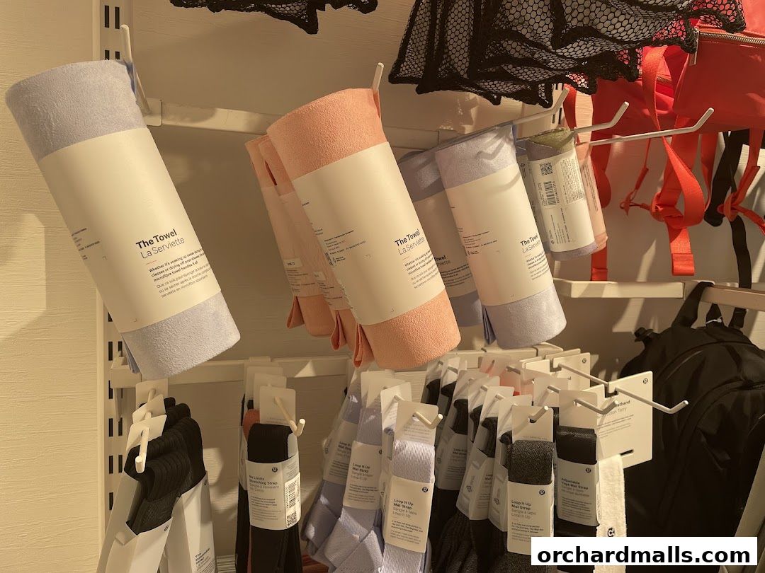 Lululemon store display featuring towels, socks, and backpacks in various colors.