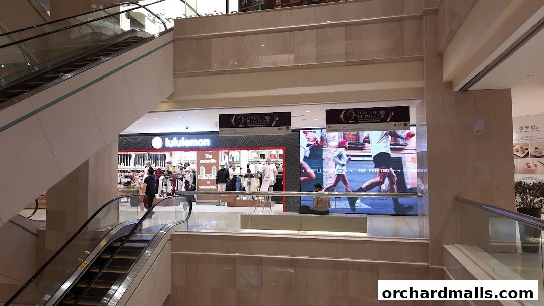 Lululemon store interior with clothing displays and digital advertisements.