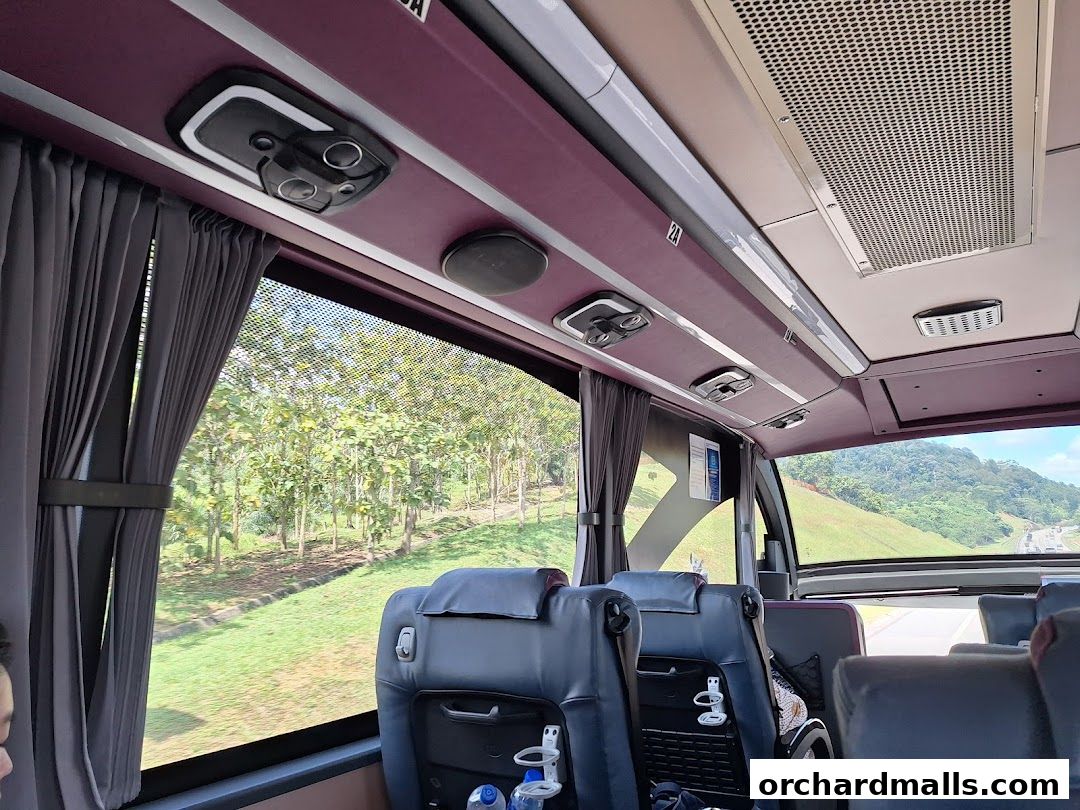 Interior view of a luxury coach bus with comfortable seating and scenic views outside.