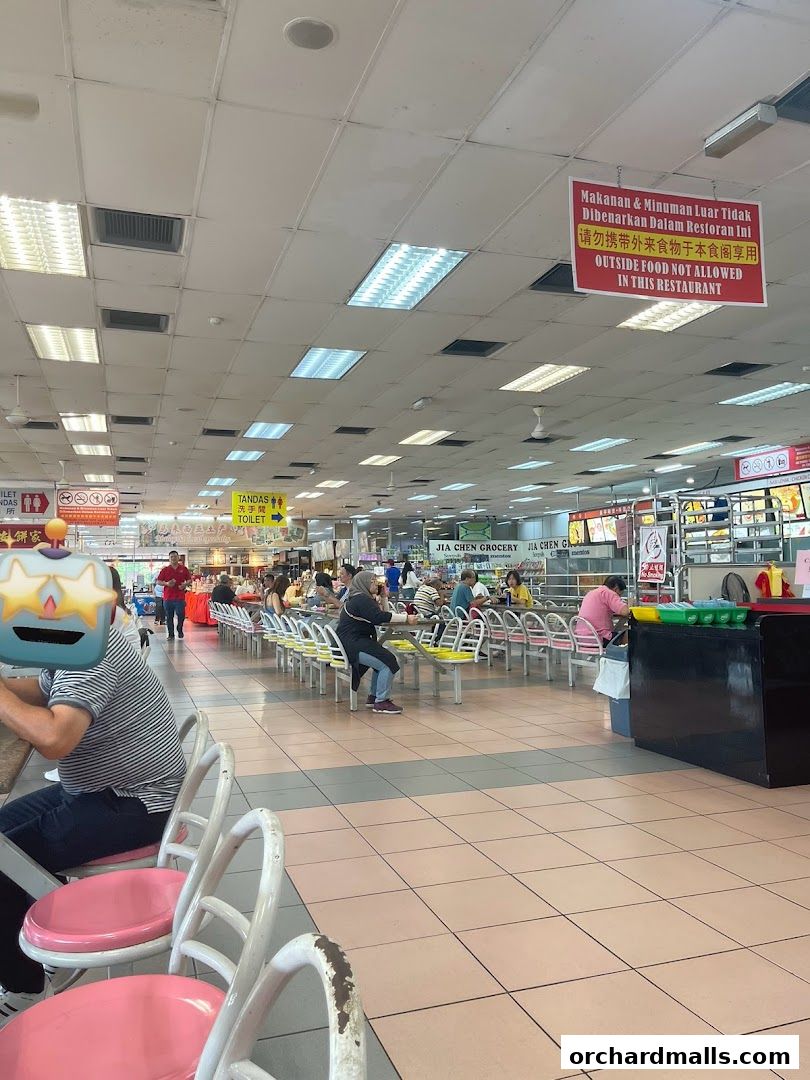 A busy food court with many tables and people eating.