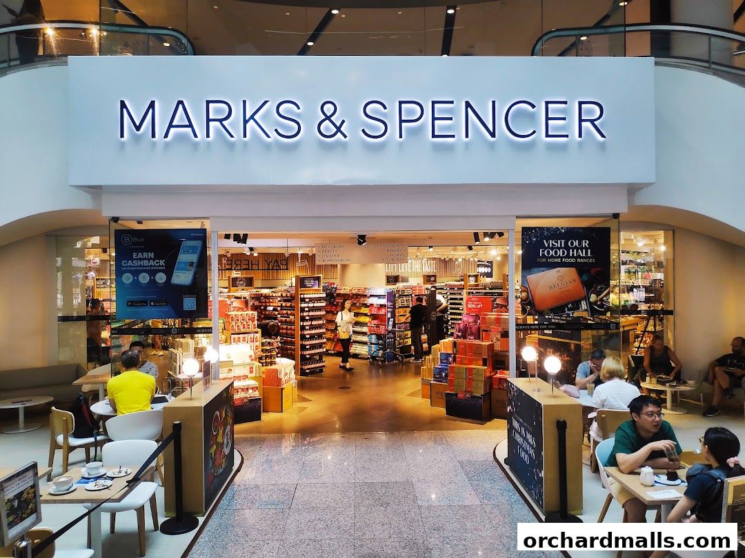 The exterior of a Marks & Spencer shop with a food hall and seating area.