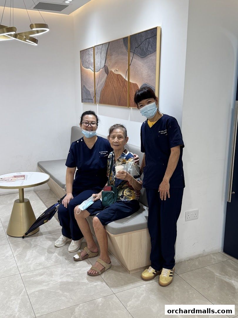 Two healthcare professionals pose with a patient in a modern waiting area.