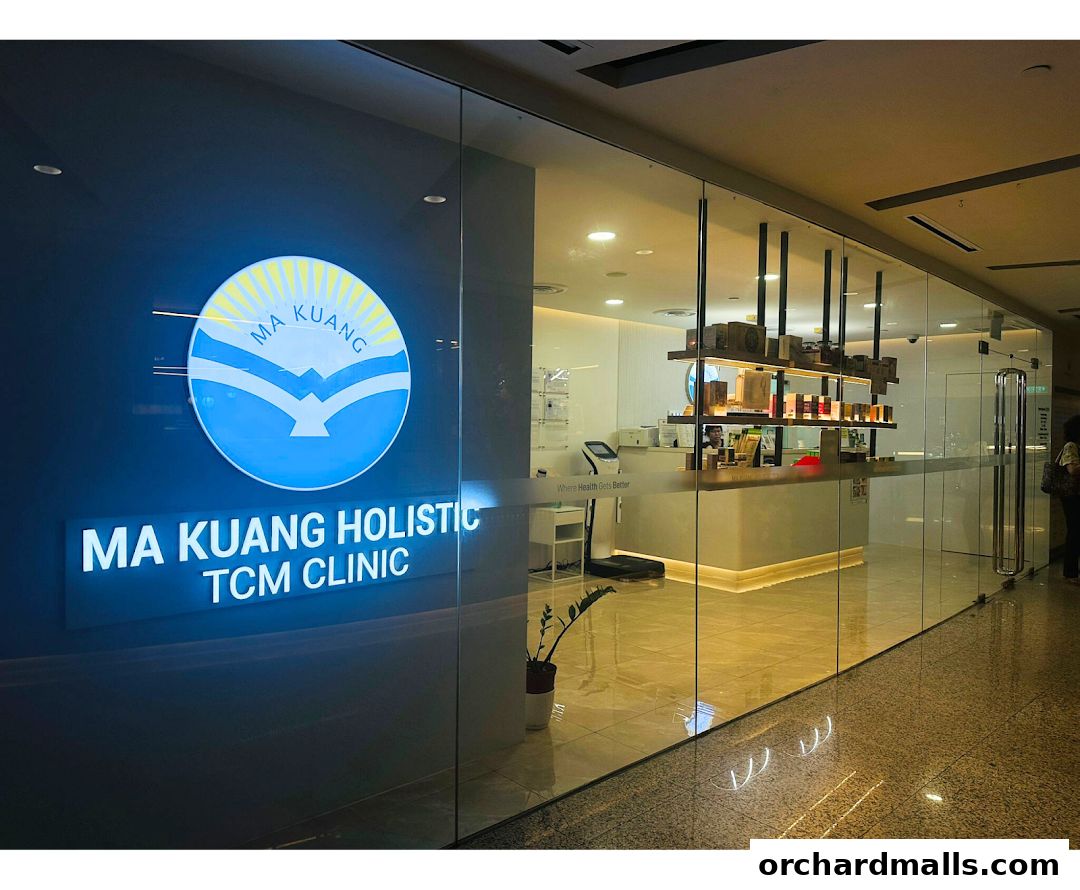 The exterior of Ma Kuang Holistic TCM Clinic with its illuminated sign and glass storefront.