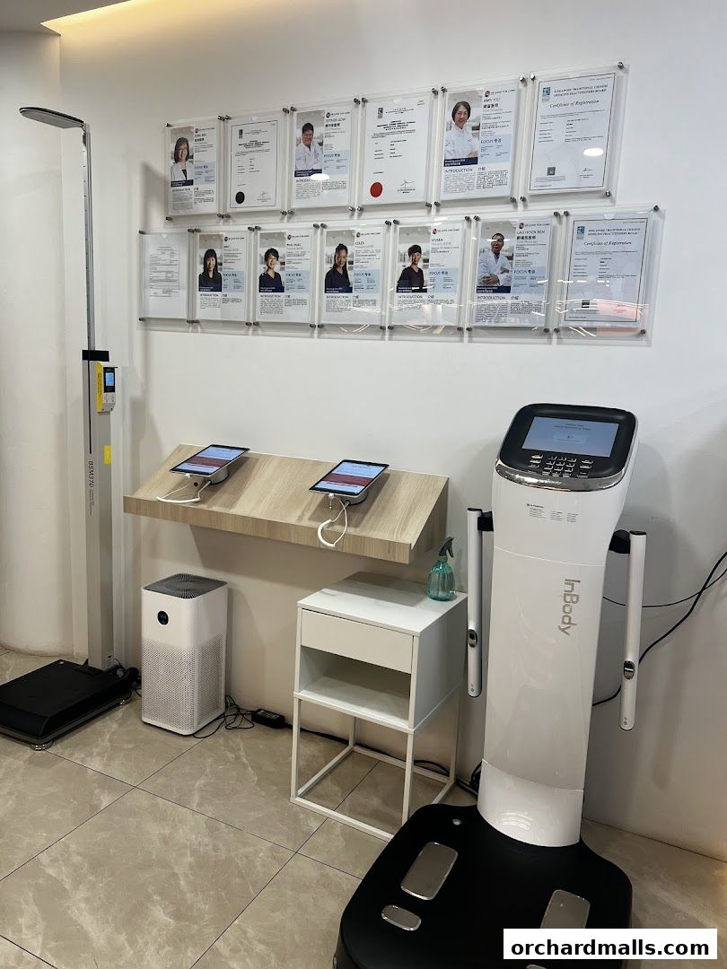 Interior of a TCM clinic with health assessment equipment and framed certificates.