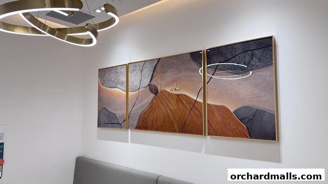 Modern abstract art featuring deer on a mountain landscape adorns a wall with a stylish light fixture.