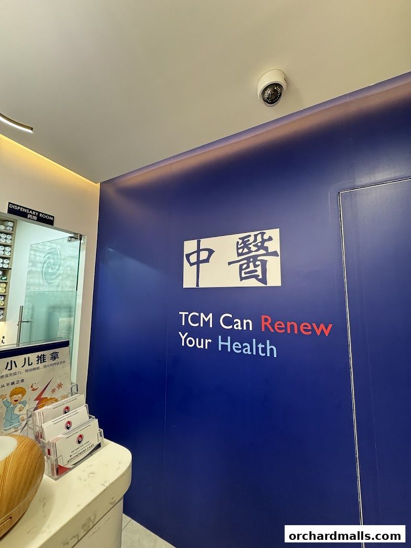 Interior view of Ma Kuang Holistic TCM with a blue wall featuring the shop's logo and slogan.