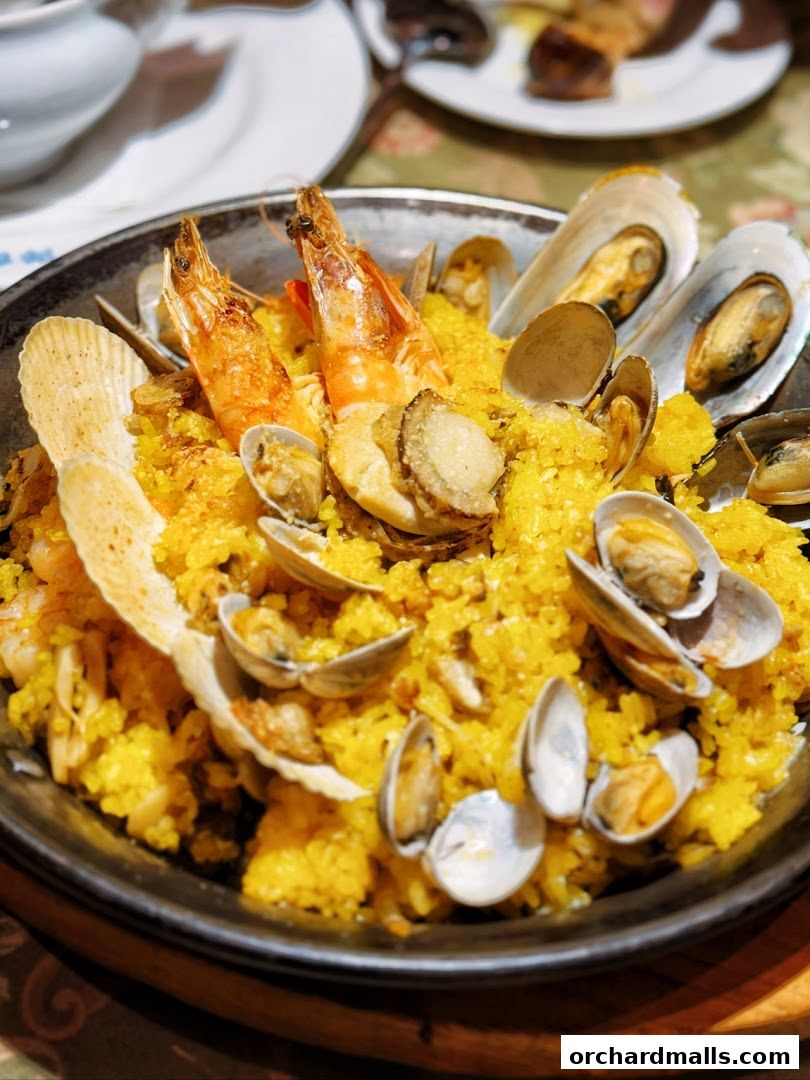 A close-up of a seafood paella dish with shrimp, mussels, and clams.