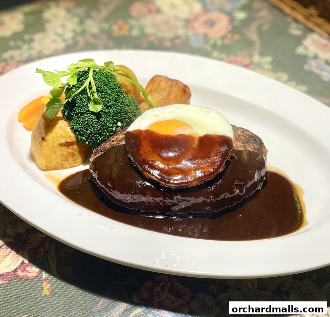 A delicious hamburger steak topped with a fried egg and rich sauce, served with vegetables.