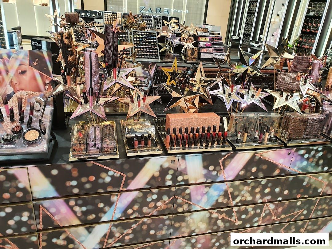 A display of MAC Cosmetics products, featuring lipsticks and eyeshadows, with star-shaped decorations.