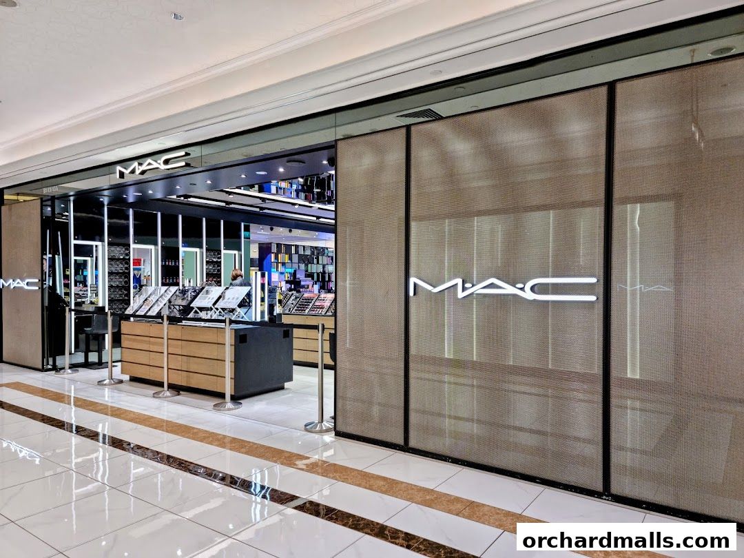 The entrance of a MAC Cosmetics store with illuminated signage and product displays.