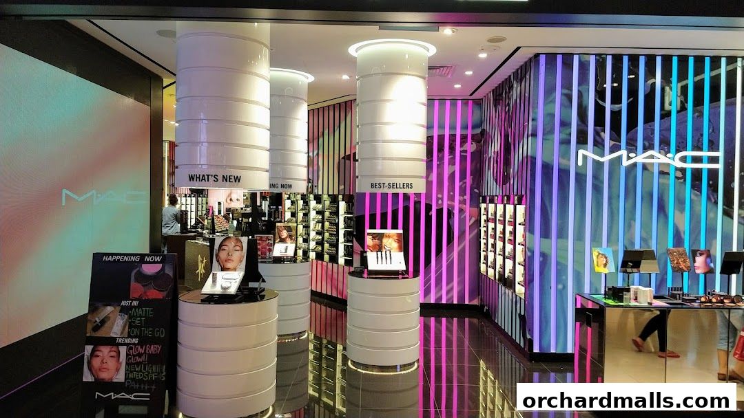 Interior of a MAC Cosmetics store with displays of makeup and promotional materials.
