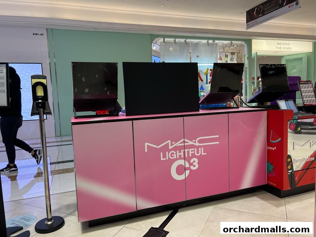 MAC Cosmetics display featuring 'Lightful C3' products with screens and pink cabinetry.