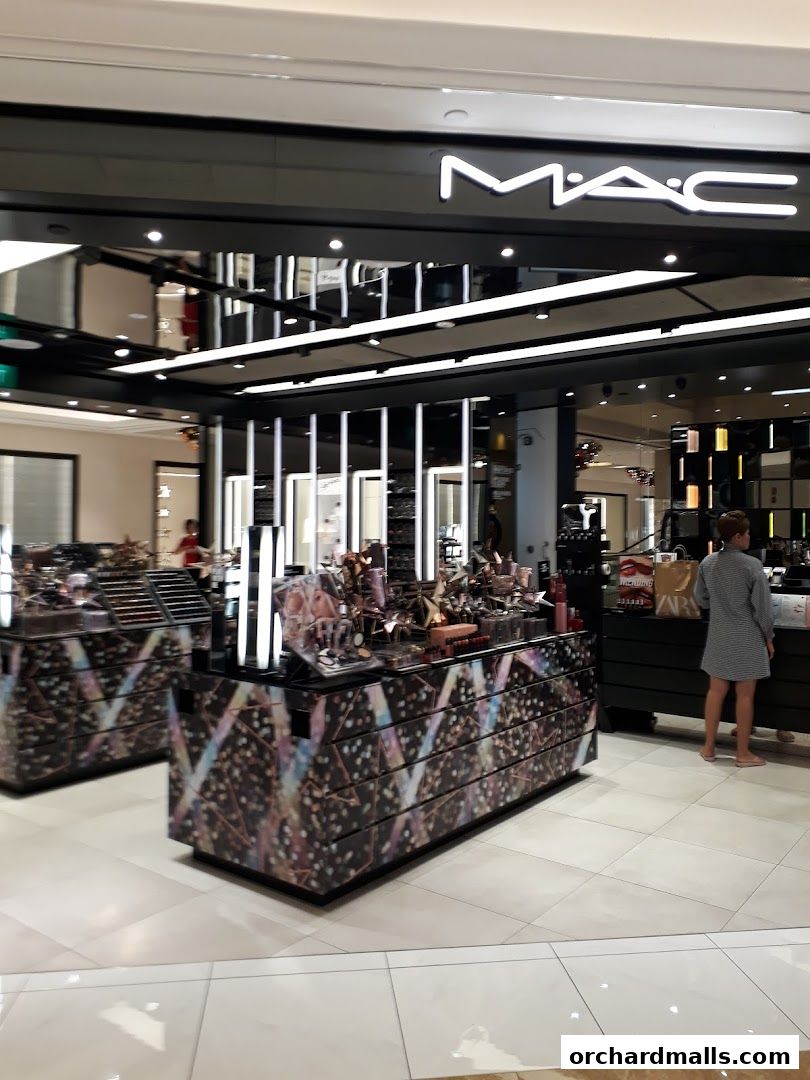 Interior view of a MAC Cosmetics store showcasing makeup displays and products.