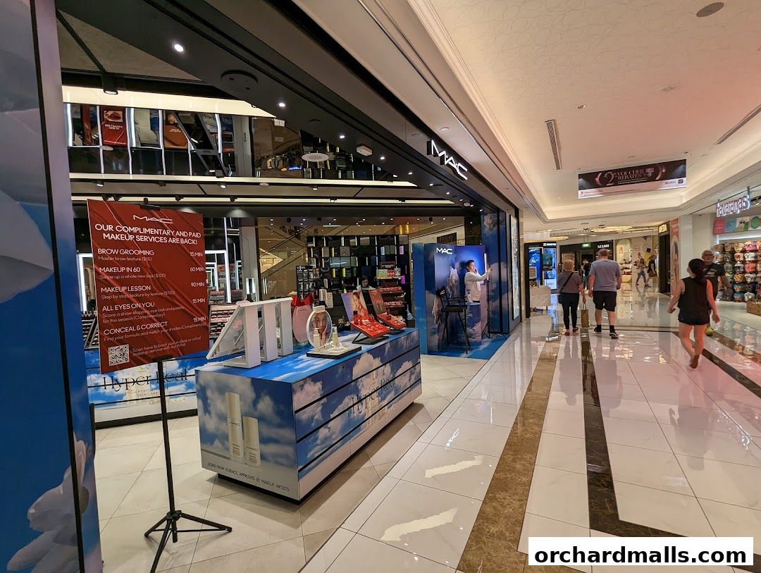 MAC Cosmetics store entrance with makeup services advertised and products on display.