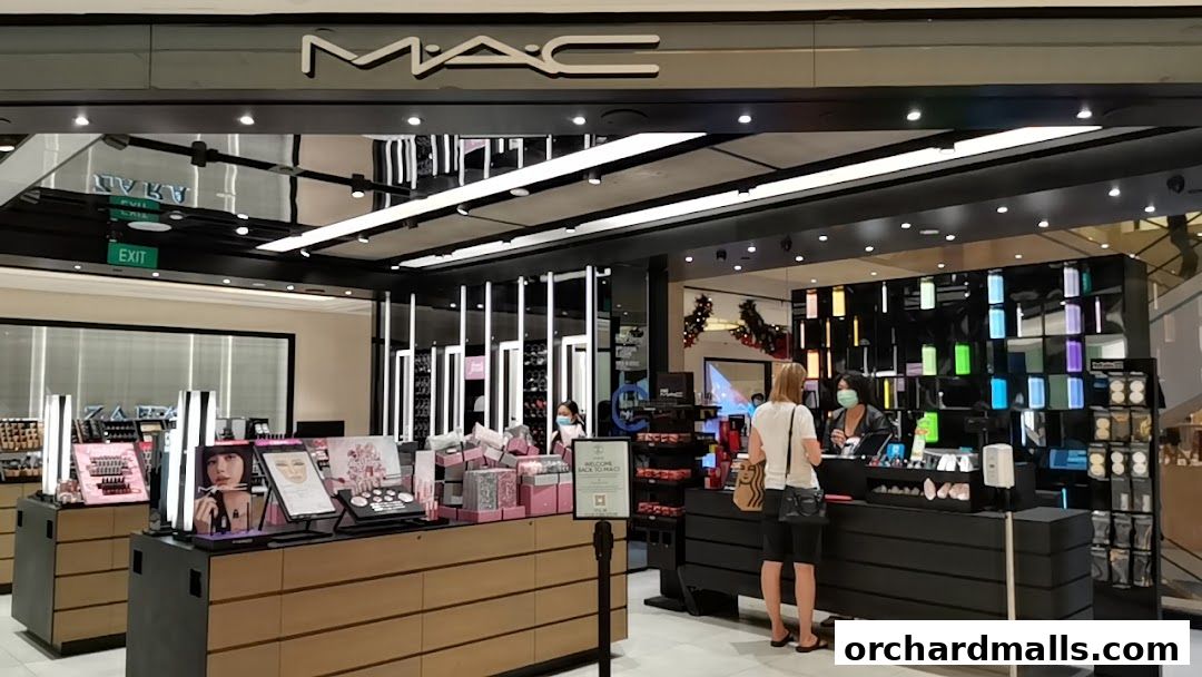 MAC Cosmetics store interior with makeup displays and customers at the counter.