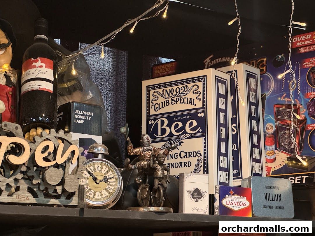 A shelf displays magic-themed items including playing cards, novelty lamps, and decorative figures.