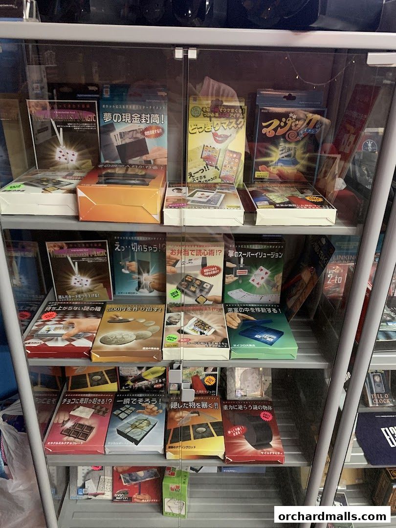 A display case filled with various magic trick kits and illusion products.