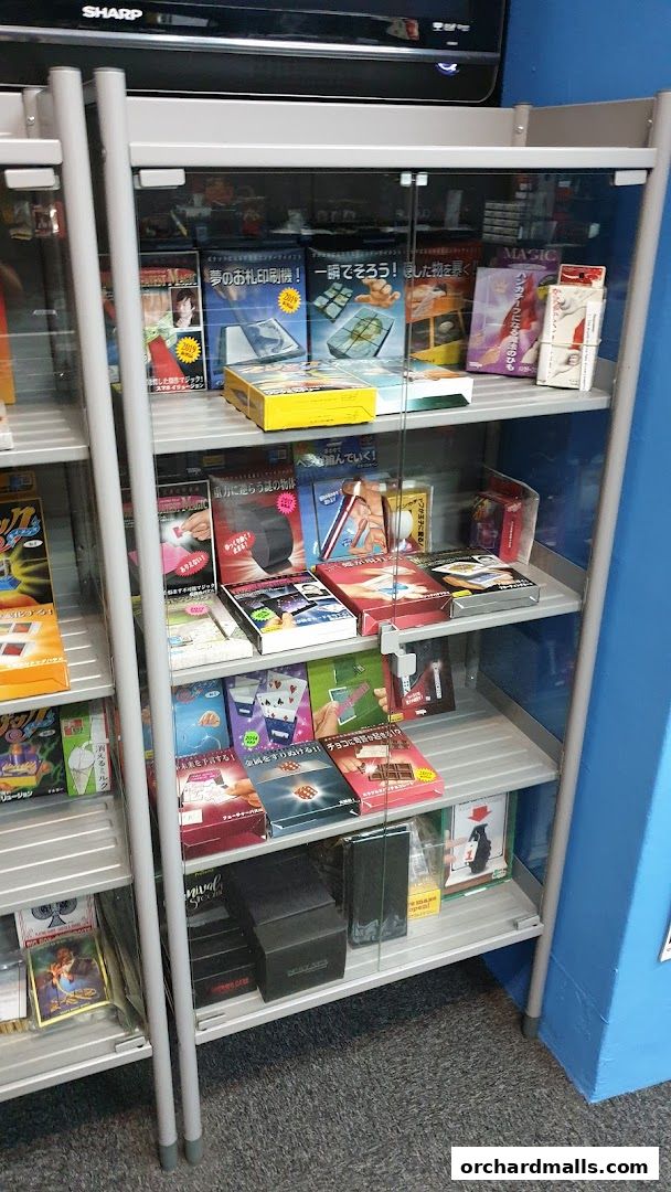 A display cabinet filled with various magic trick kits and illusion products.