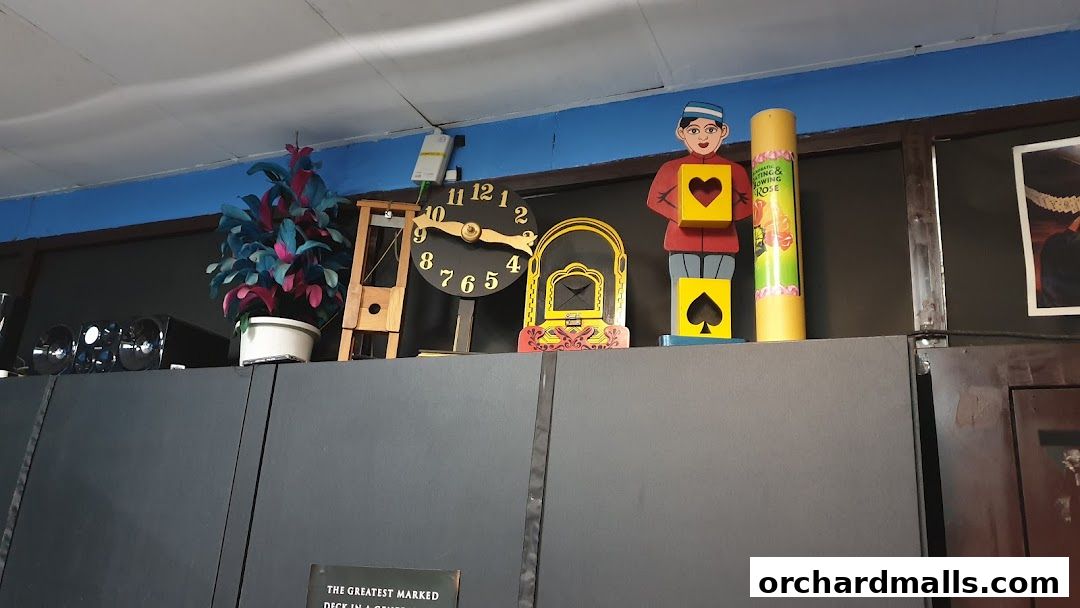 A display of magic-themed props including a guillotine, clocks, and figures.
