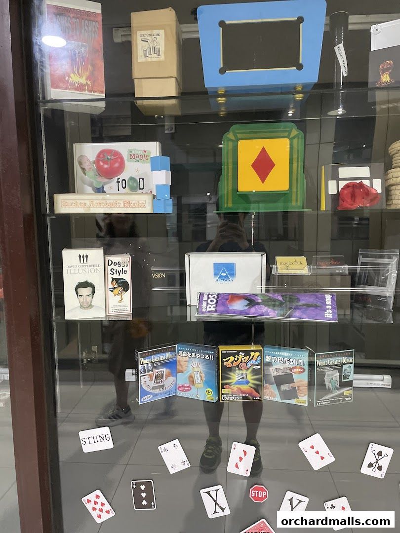 A display case filled with various magic tricks, books, and playing cards.