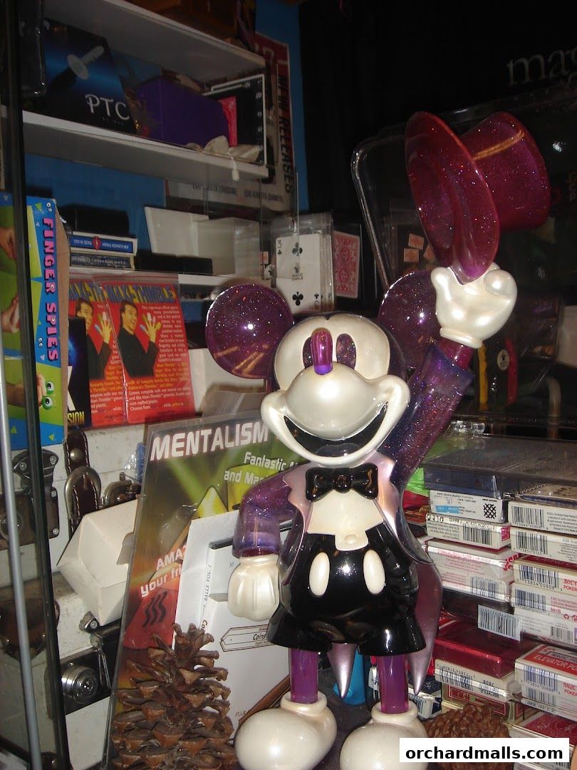 A Mickey Mouse figure dressed as a magician, surrounded by magic trick items.