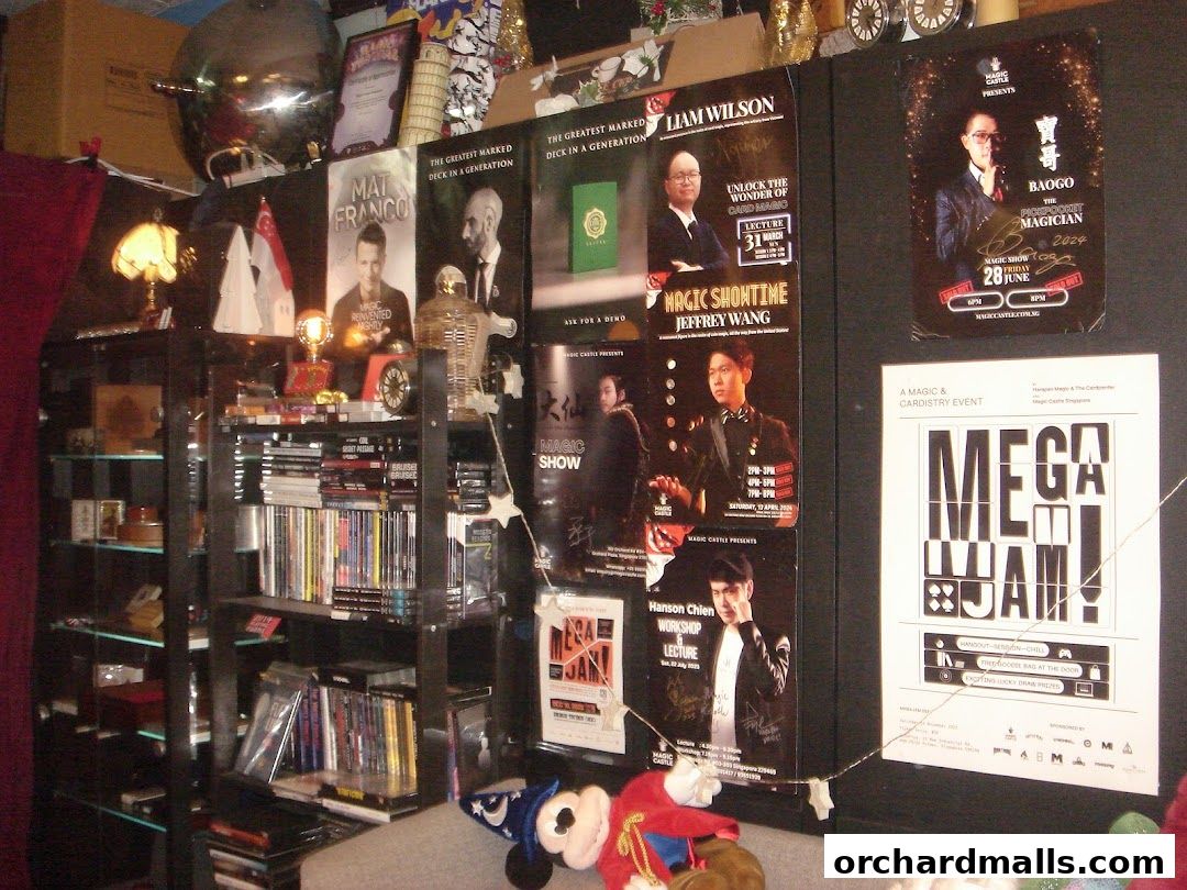 A wall display of magic show posters and shelves filled with books and DVDs.