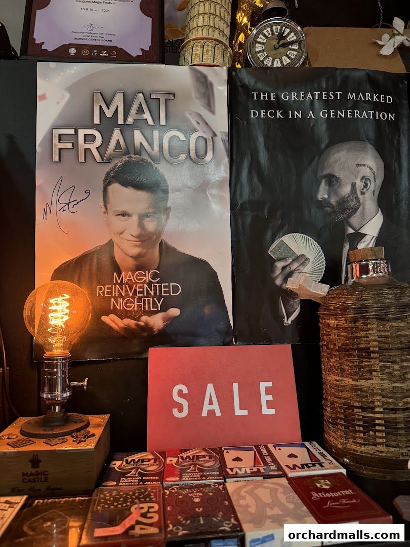 A display of magic-themed posters, playing cards, and a 'SALE' sign.
