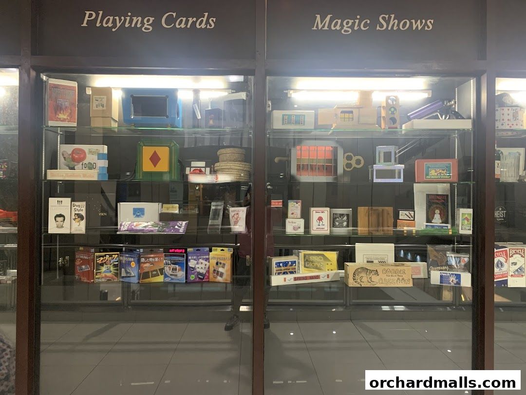 Display cases filled with magic tricks, playing cards, and magic show props.