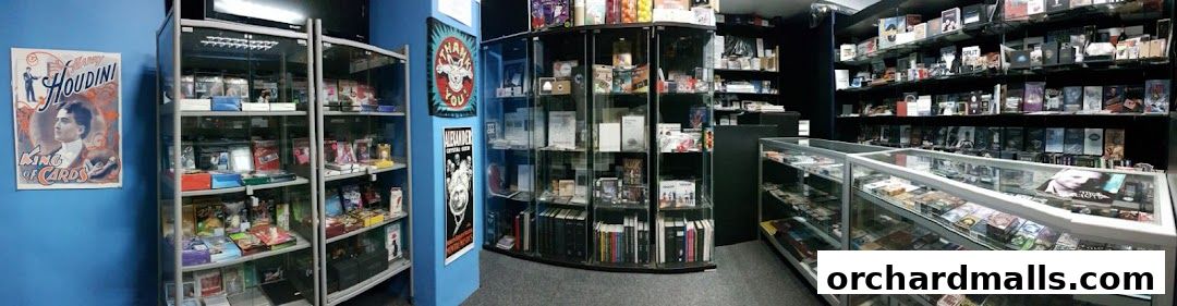 Interior view of a magic shop with shelves and display cases filled with magic tricks and books.