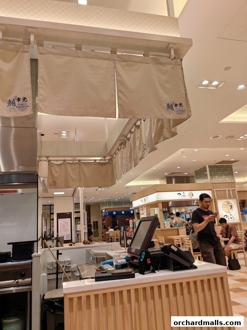 Interior view of Maguro Yukimitsu restaurant with noren curtains and a cashier counter.