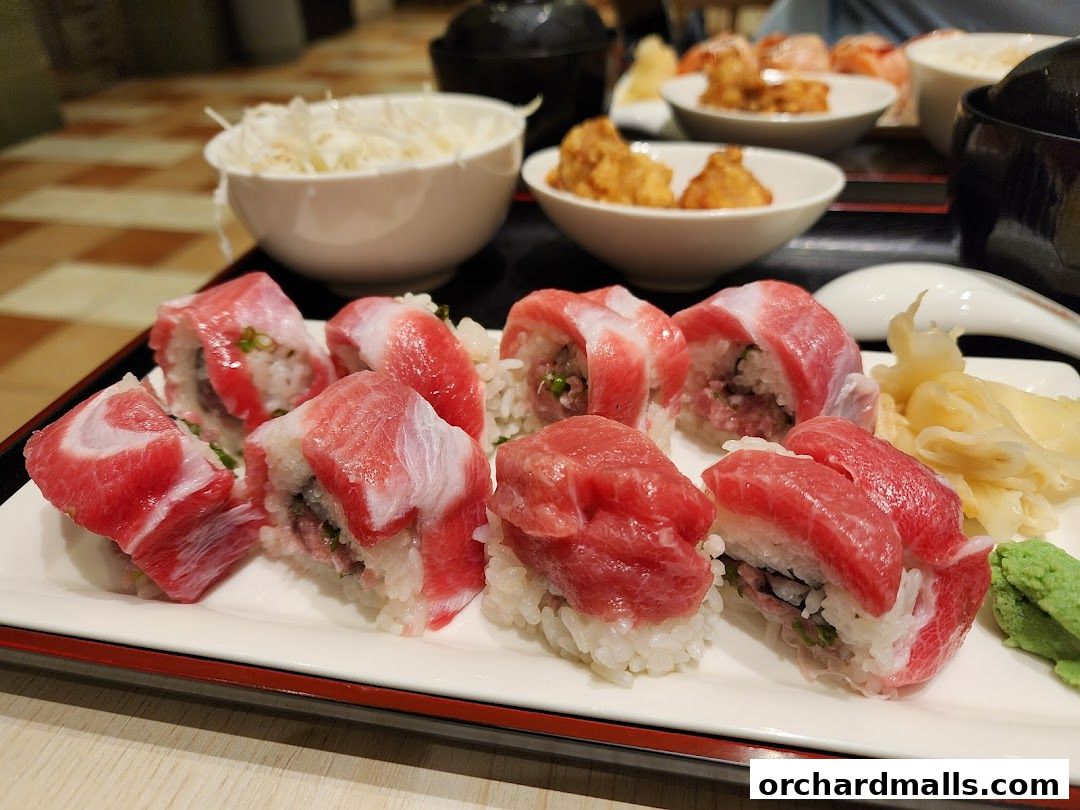 A close-up of fresh tuna sushi rolls and nigiri served with wasabi and ginger.
