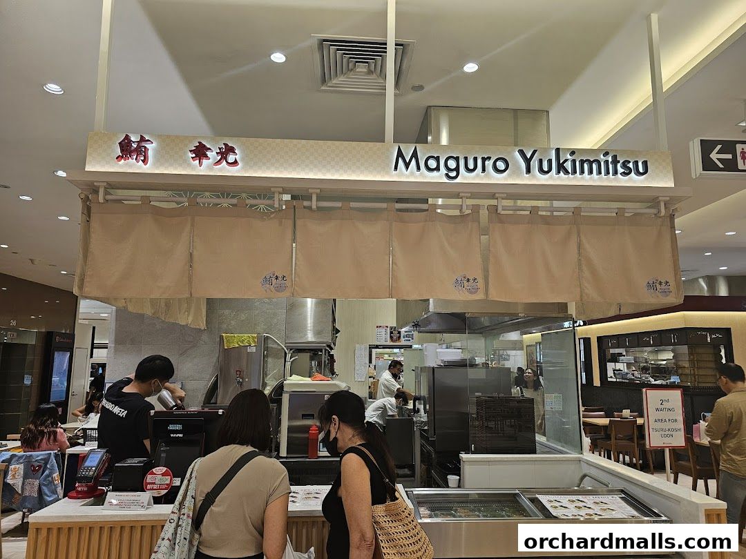 The storefront of Maguro Yukimitsu, a Japanese restaurant, with staff serving customers.