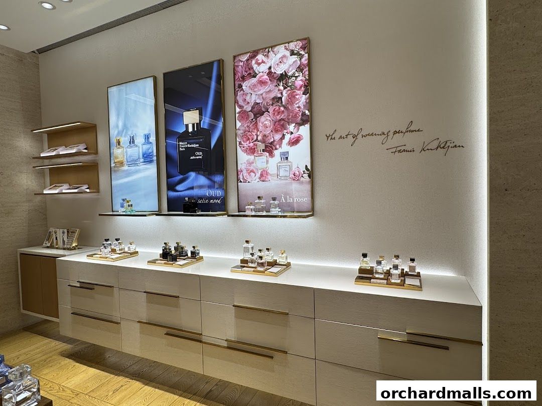 Interior of a luxury perfume store displaying various fragrances and promotional artwork.