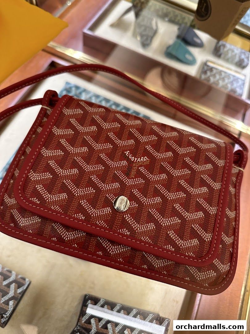 A close-up of a red Goyard handbag with the signature pattern displayed in a shop.