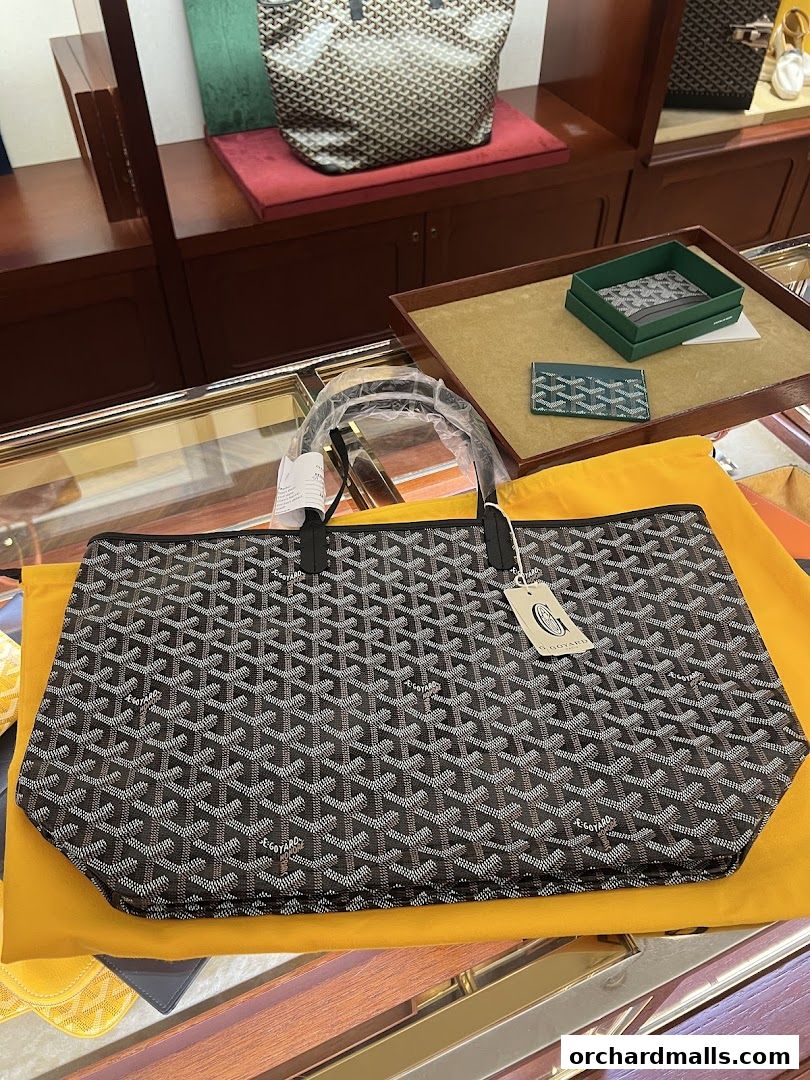 Goyard tote bag and cardholder displayed in a luxury retail store.