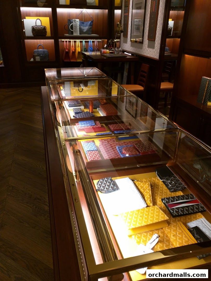 A display case filled with Goyard wallets, cardholders, and small leather goods.