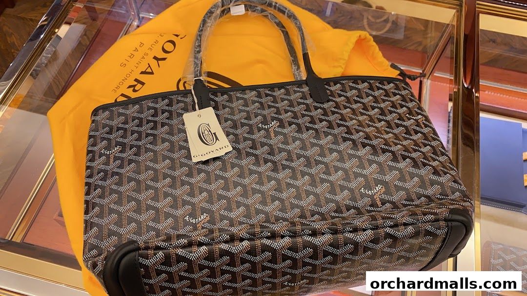 A Goyard tote bag with its signature pattern and dust bag on display.