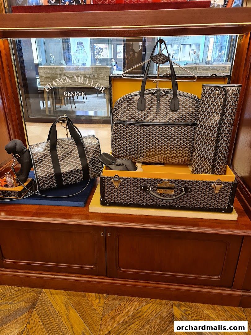 Goyard luggage and accessories displayed in a luxury store window.