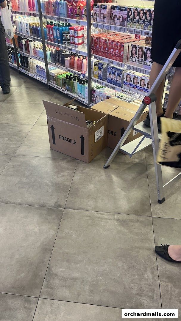 Shelves stocked with beauty products and boxes on the floor in a retail store.