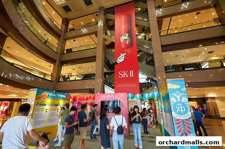 People gather around promotional displays and a large SK-II banner in a mall atrium.