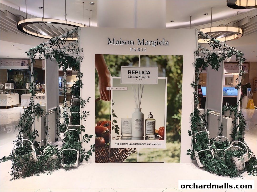 Maison Margiela display featuring Replica fragrances with floral and basket accents.
