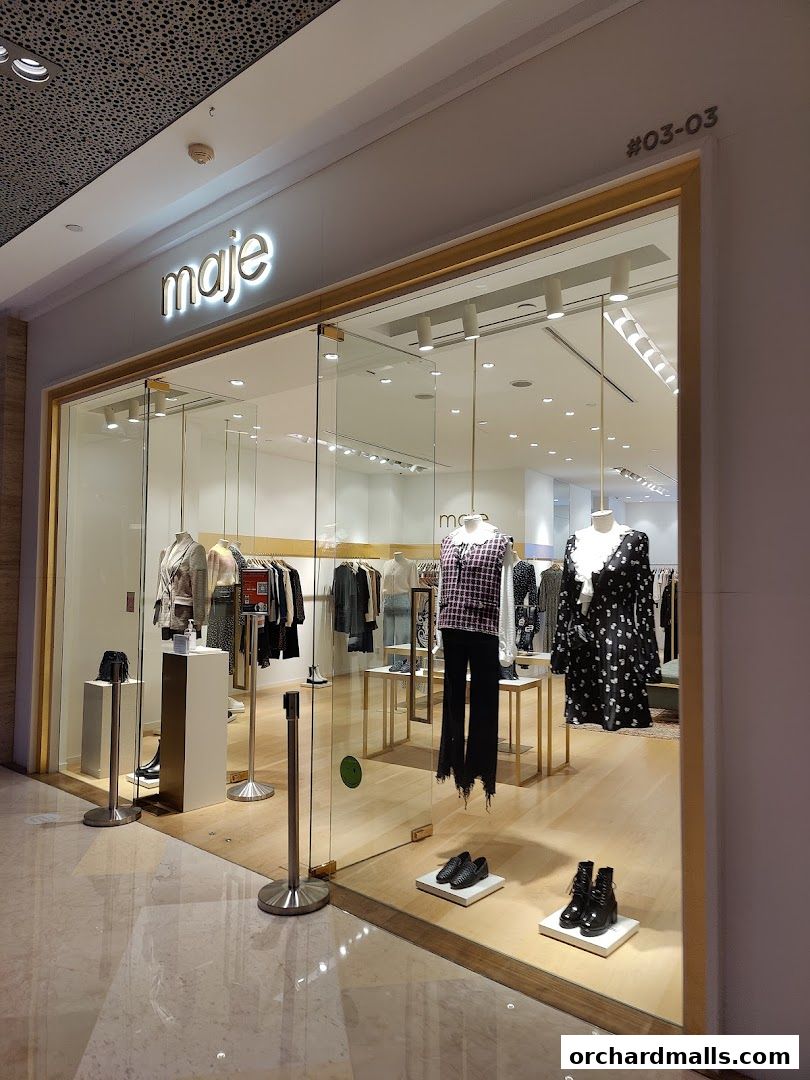 The Maje shop front displays mannequins dressed in stylish clothing and shoes in a well-lit store.