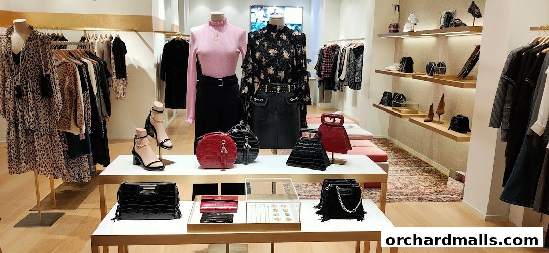 Interior view of a Maje boutique showcasing stylish clothing, handbags, shoes, and accessories on display.