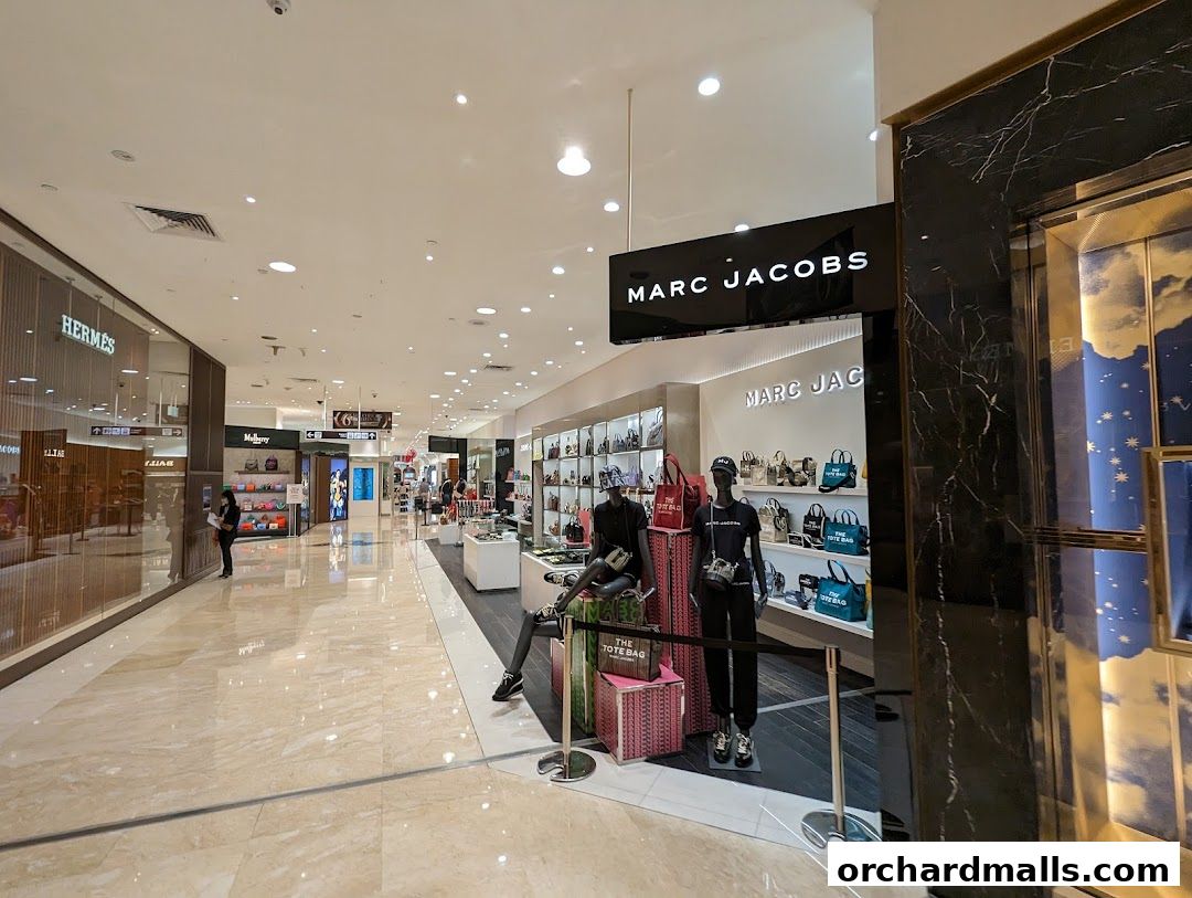 The Marc Jacobs store entrance with mannequins displaying handbags and the brand's logo.