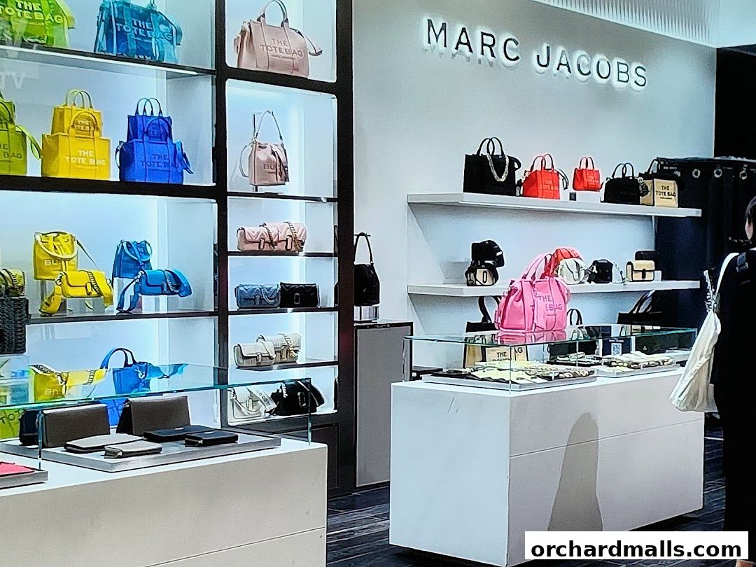 Interior view of a Marc Jacobs store showcasing colorful handbags and accessories on display.